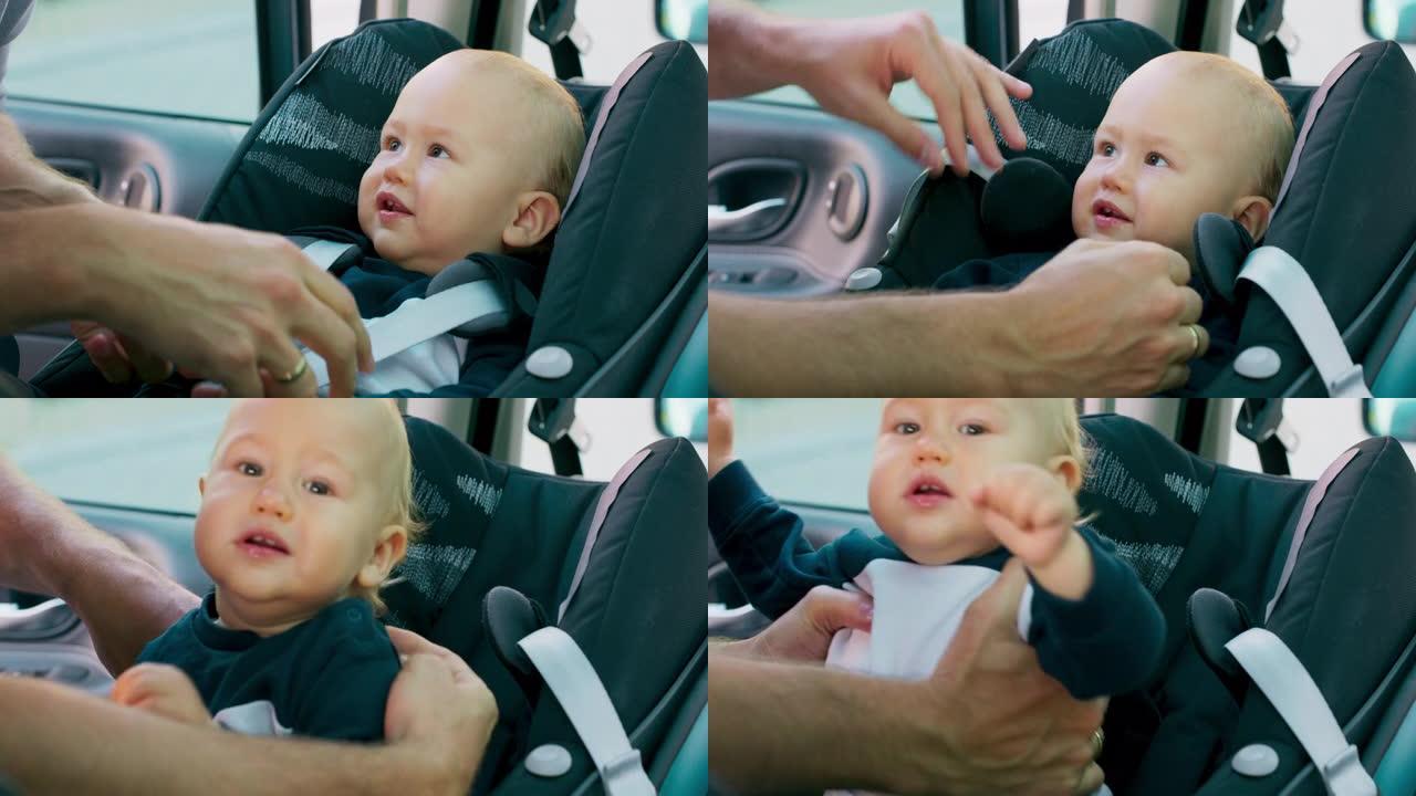 车内摄像头。特写男婴坐在车内的婴儿汽车座椅上。父亲的手解开安全带，将婴儿从汽车座椅上带走。宝贝直视镜