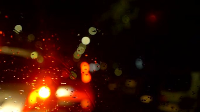 汽车在雨夜在城市交通中行驶。汽车，夜晚，下雨，小心