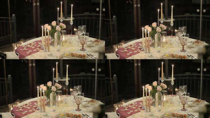 浪漫晚餐的桌子。为恋人提供蜡烛和餐具的桌子