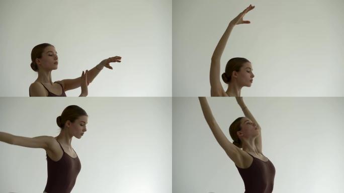 一位年轻苗条的芭蕾舞演员用双手表演优美的舞曲。在明亮的舞蹈工作室排练。在白色背景中拍摄特写