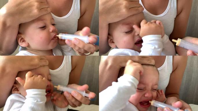 母亲用注射器给婴儿服药