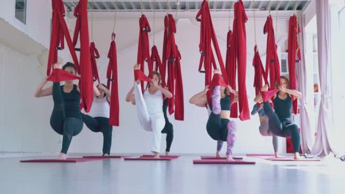 集中女性练习战士空中飞行瑜伽体式
