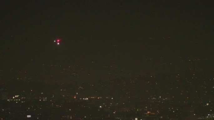 加州洛杉矶肯尼斯·哈恩公园 (Kenneth Hahn Park) 的一架直升机在洛杉矶上空的夜景