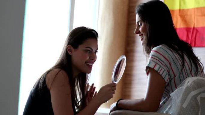 偷拍的女人在手镜前看着自己，随意的朋友化妆