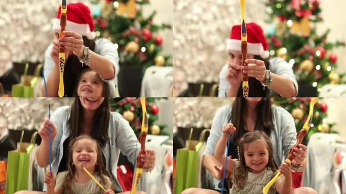 妈妈和小女孩在圣诞节期间一起玩射箭玩具
