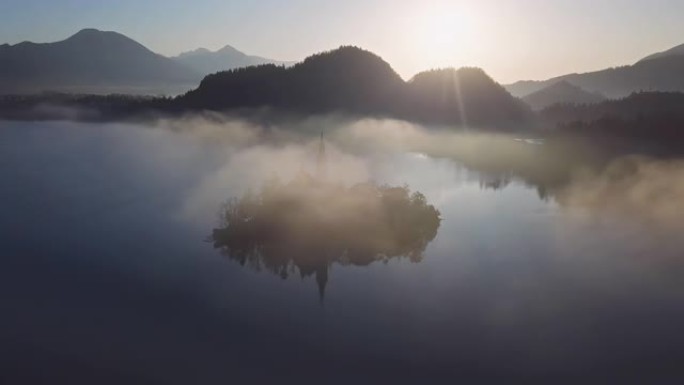 鸟瞰图的布莱德岛(布莱斯基otok)与朝圣教堂的圣母升天在湖流血在晴朗的秋天早晨与轻雾，斯洛文尼亚