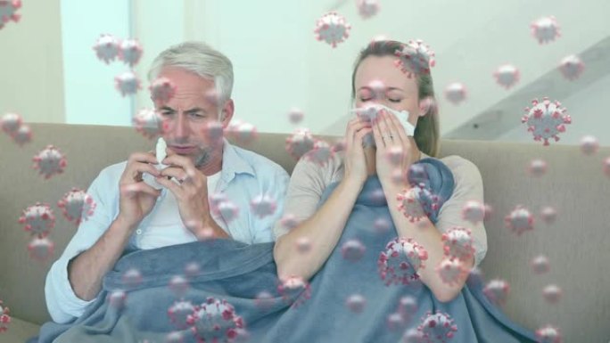 漂浮在白人夫妇坐在沙发上打喷嚏的巨集新型冠状病毒肺炎细胞的动画