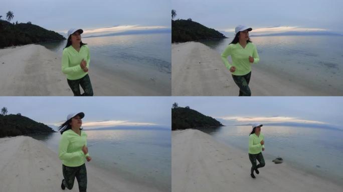亚洲妇女早上在海滩上跑步运动。慢动作