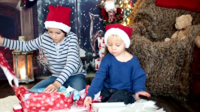 漂亮的孩子，蹒跚学步的孩子和小学生，在圣诞节之夜打开礼物，偷偷溜进房间