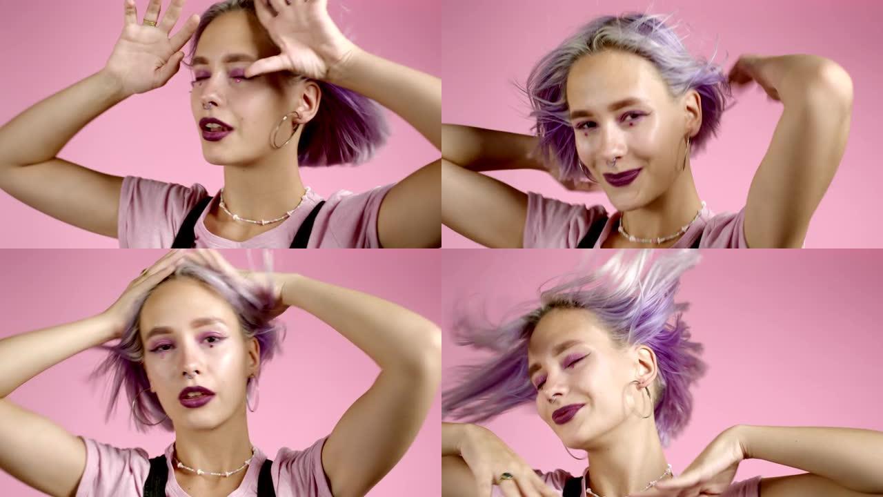 美丽的时髦女人在粉红色的工作室背景下积极活跃地用彩色发型跳舞。可爱的女孩的肖像。派对，幸福，自由，青