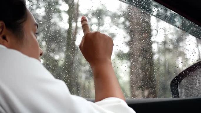 悲伤的年轻女子在雨天孤独地坐在车里想着她的爱人。