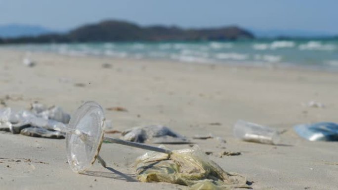 塑料和吸管被冲走，埋在海边的沙子里。