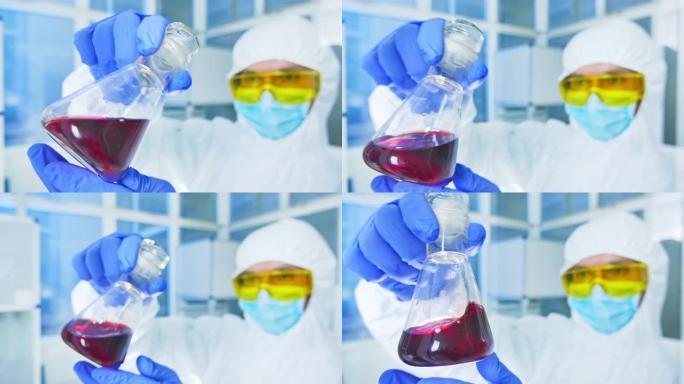化学实验室-防护服中的科学家分析实验室烧瓶中的液体