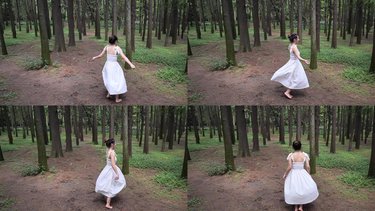 高视角的美丽中国年轻女子穿着白色连衣裙在森林公园跳舞，无忧无虑的女孩快乐旋转，享受大自然中的自我，超