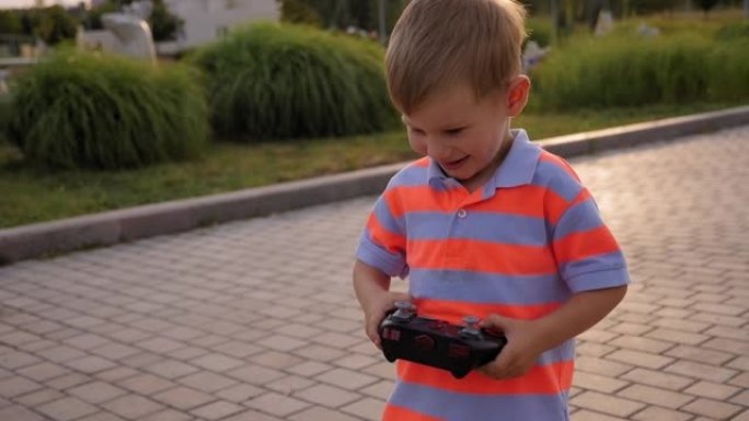 公园里一个用无线电遥控汽车遥控的小男孩。