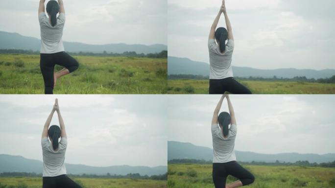年轻的亚洲妇女做瑜伽练习冥想，在日出时在山景中表演精神瑜伽姿势。