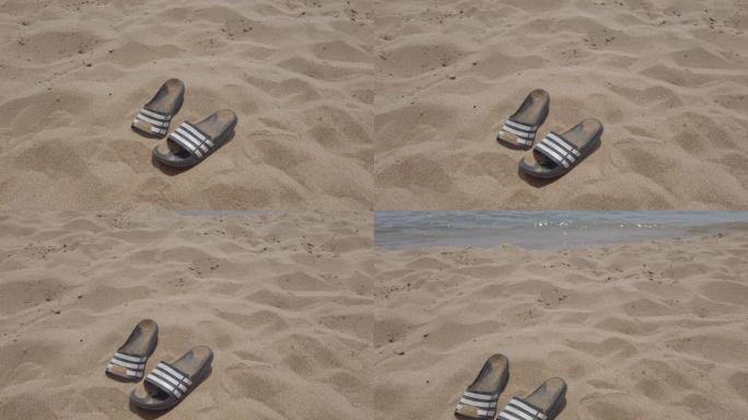 男士黑色拖鞋在海边的沙滩上