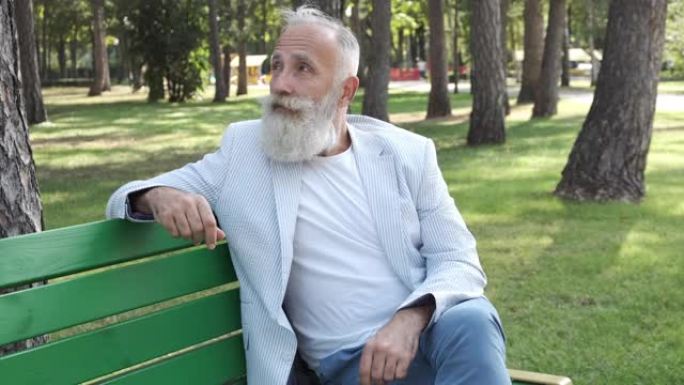 一位老人在公园里休息时正在四处张望。一个人