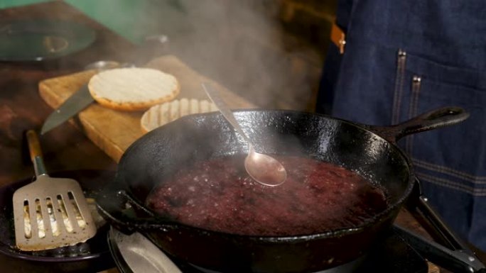 野生有机蔓越莓酱在铁锅中加热，白色蒸汽上升，烹饪概念。库存镜头。汉堡甜酱的制作过程