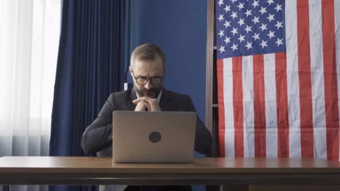 微笑的商业复古，白人绅士，白种人与美国或美国国旗在家里工作的桌子上的电脑笔记本电脑在网络视频电话会议