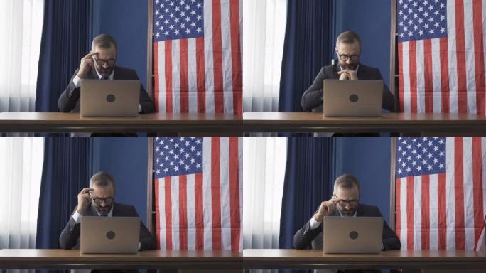 微笑的商业复古，白人绅士，白种人与美国或美国国旗在家里工作的桌子上的电脑笔记本电脑在网络视频电话会议