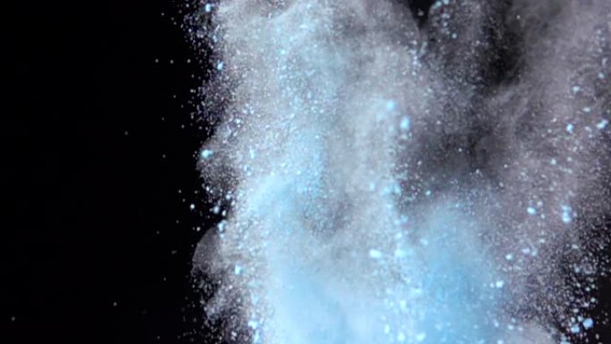 彩色蓝色粉末在黑暗孤立背景上的超慢动作爆炸。粉末团向上飞，与烟雾混合。