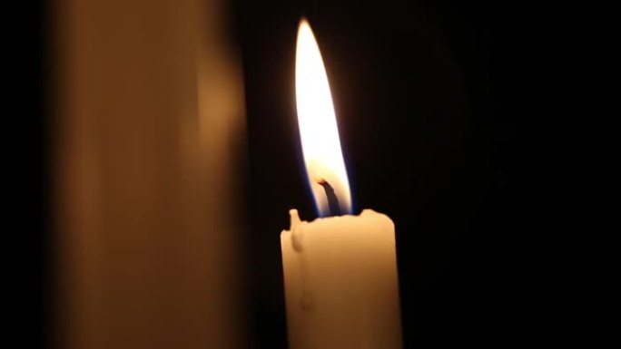 火焰蜡烛特写在一个黑色的背景。