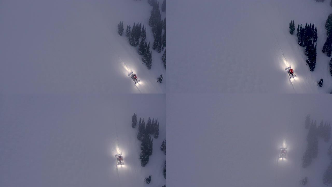 雪道美容师在雪原上行驶以改善步道条件的高上方滑雪坡视图