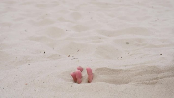 雄性的手拿了一把干沙，让它掉下来。海滩度假，度假。