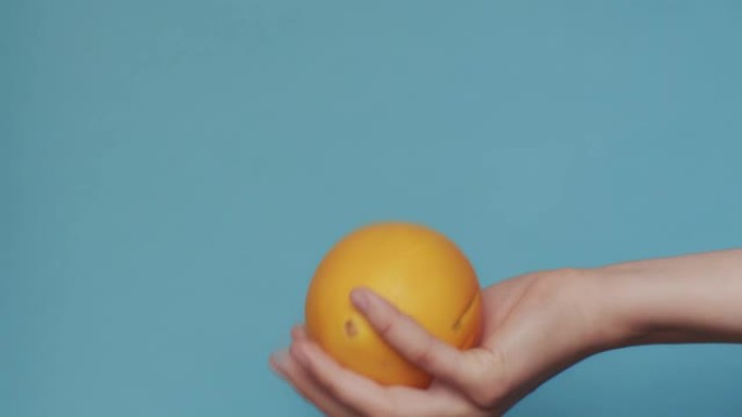 女性手扔新鲜橙色并抓住它的宏视频拍摄