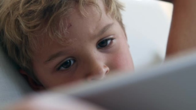 孩子的脸盯着屏幕特写。被催眠的孩子在线观看媒体
