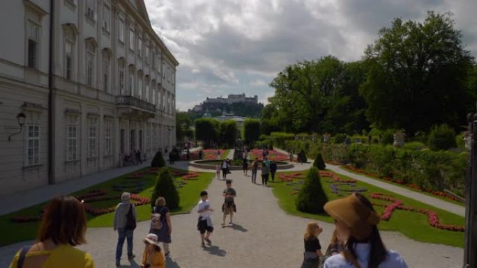 阳光明媚的夏日萨尔茨堡市著名旅游拥挤花园慢动作全景4k奥地利