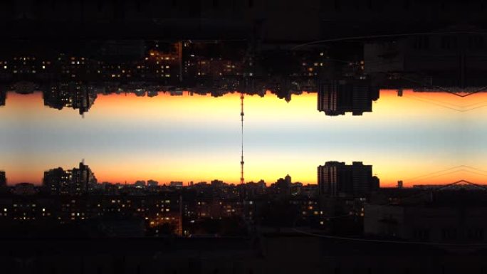 日落时颠倒的橙色城市景观，垂直反射。