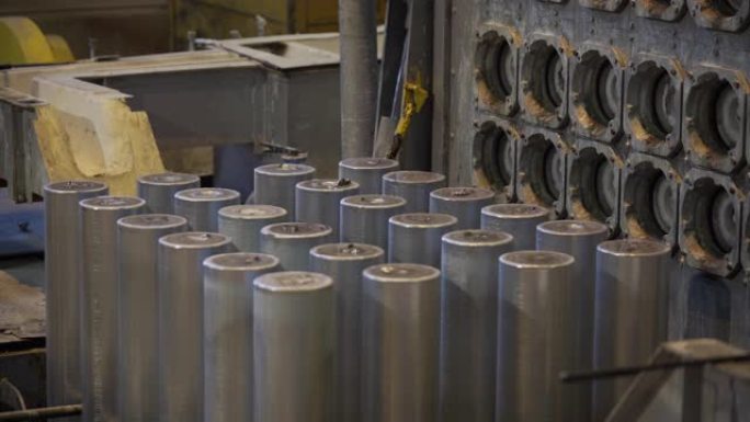在现代工厂熔化后形成铝柱。生产铝金属型材，通常用作建筑和制造材料。