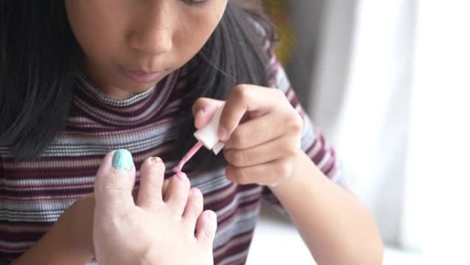 亚洲女孩在家为母亲画指甲脚趾，周末水疗概念。