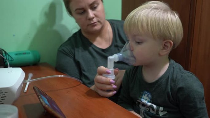 一个三岁的孩子戴着氧气面罩呼吸。吸入呼吸道。面罩吸入器。