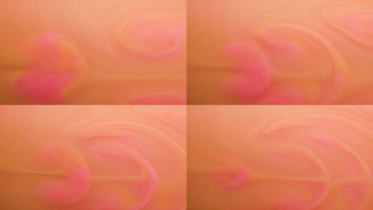 时尚背景彩色橙色和粉红色油漆在水中混合，在水下轻柔旋转。特写视图。多色丙烯酸涂料，化妆品时尚。慢动作