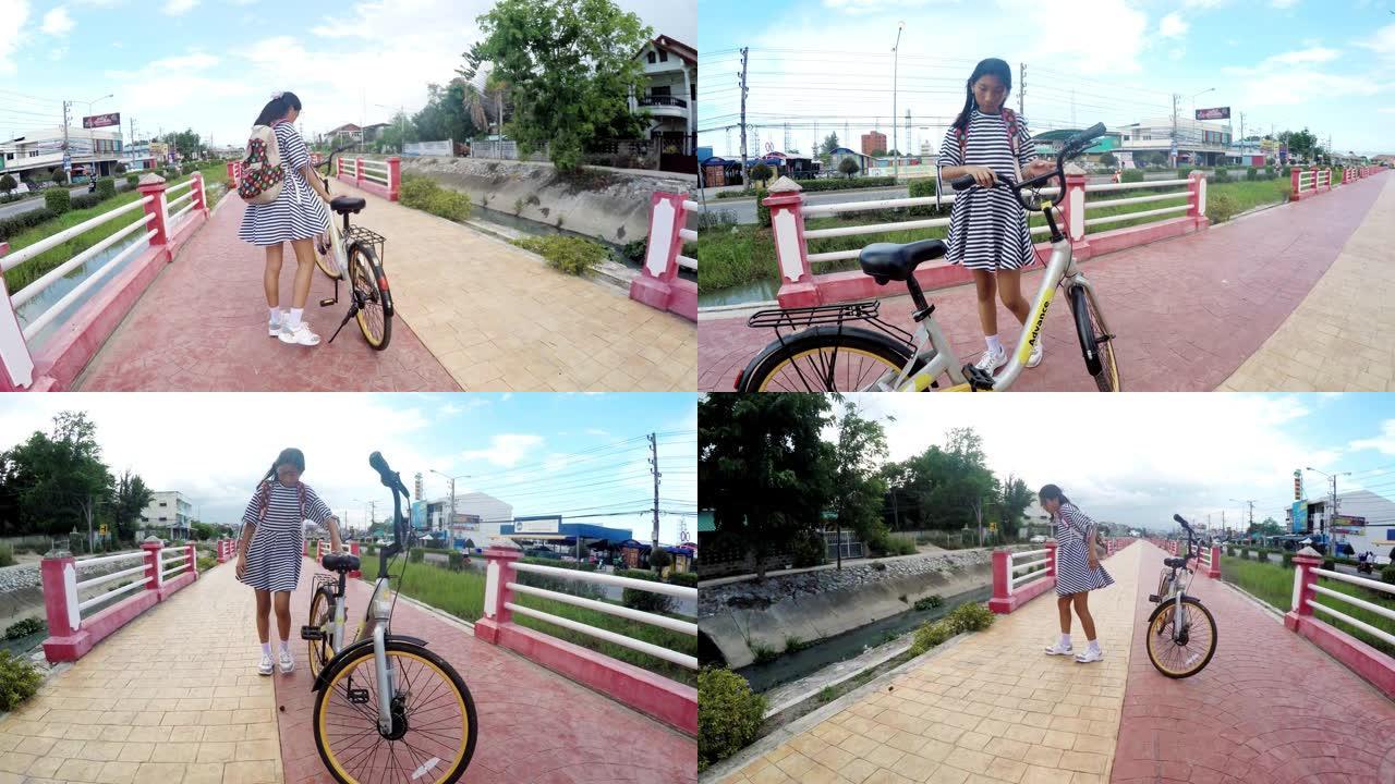亚洲女孩在小路上骑自行车，运动概念。