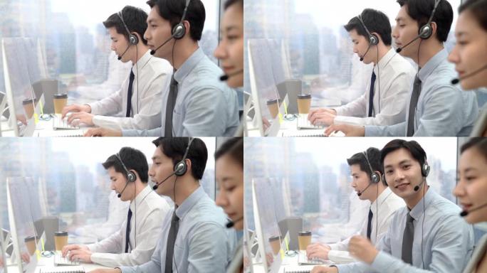 呼叫中心城市办公室年轻微笑的亚洲男性电话营销运营商
