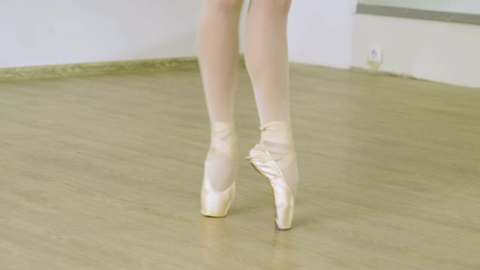 在工作室里，女芭蕾舞演员的脚在脚尖上跳舞。4K