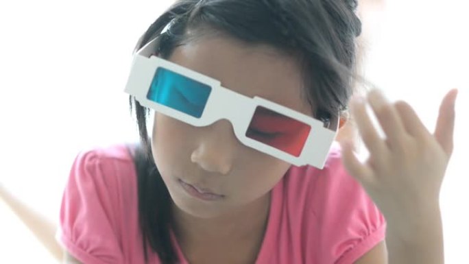 躺在床上戴着3d眼镜的亚洲女孩在家窗户附近看书。
