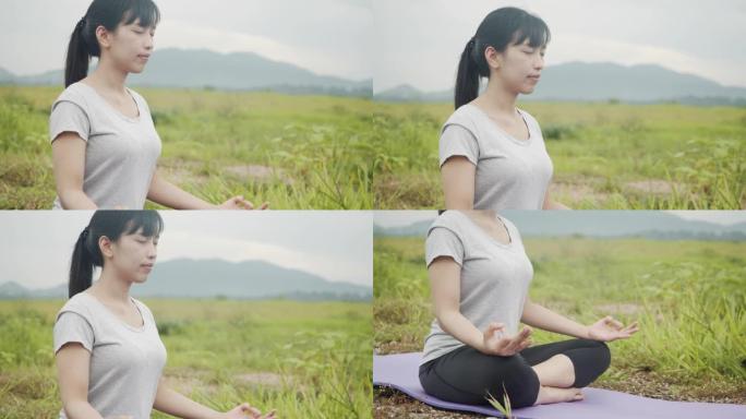 早晨日出时，坐在冥想中的年轻白人妇女在美丽的山景中摆姿势瑜伽体式平衡。