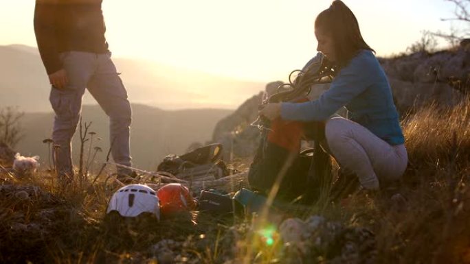 幸福的年轻夫妇收拾背包在阿尔卑斯山远足。背景中的塑料袋