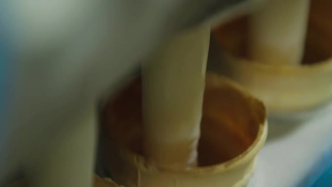 冰淇淋生产线的特写镜头。冰淇淋厂用冰淇淋填充威化杯