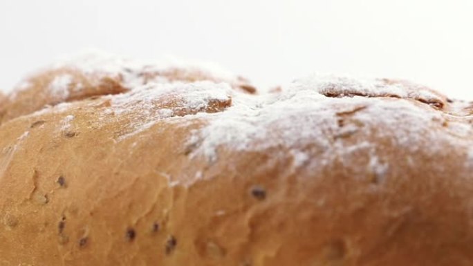 饮食面包面包旋转，面粉在白色背景上方特写