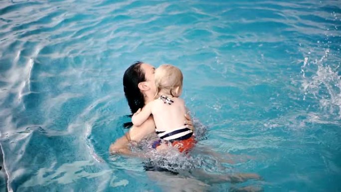 游泳池。妈妈教小孩子游泳。