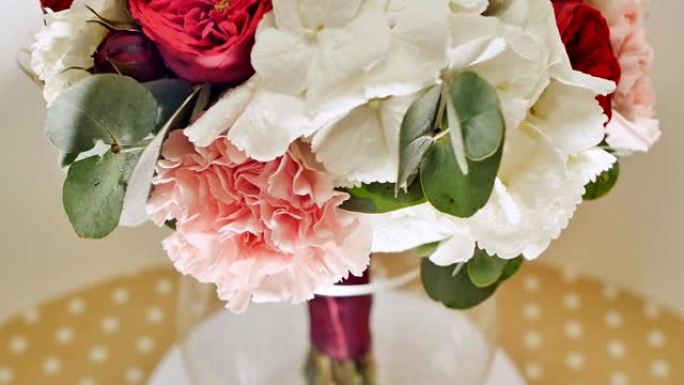 婚礼花束的绣球花，介子形玫瑰，康乃馨和桉树绿色。旋转花束