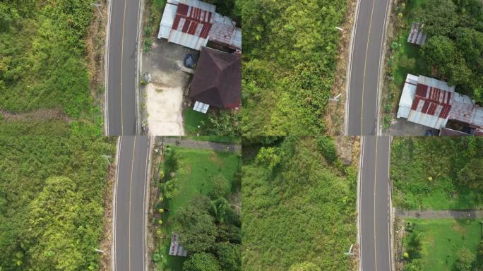上方的视图是一条小的两车道道路，中间是一条黄线，两侧是电线，而房屋则在旁边弹出