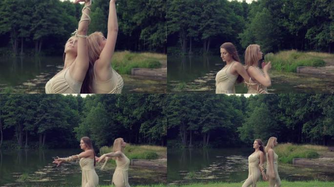 两个漂亮的年轻女孩金发碧眼和黑发在大自然中跳舞。