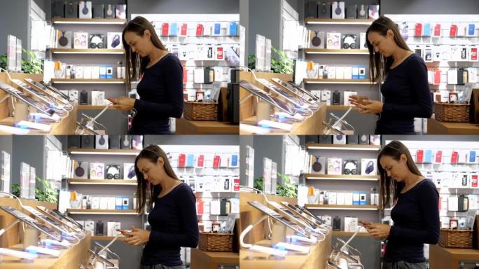 年轻女子在一家电子商店选择一款新的智能手机。